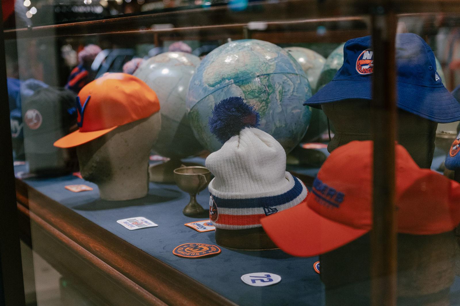 Vintage and heritage-inspired New York Islanders hats, knit caps and collectibles displayed inside Isles Lab at UBS Arena. Love & War developed the Isles Lab concept, naming, branding and merchandise program, drawing on Islanders history and New York culture to create a distinctive retail experience that blends NHL heritage with contemporary sportswear and fashion.