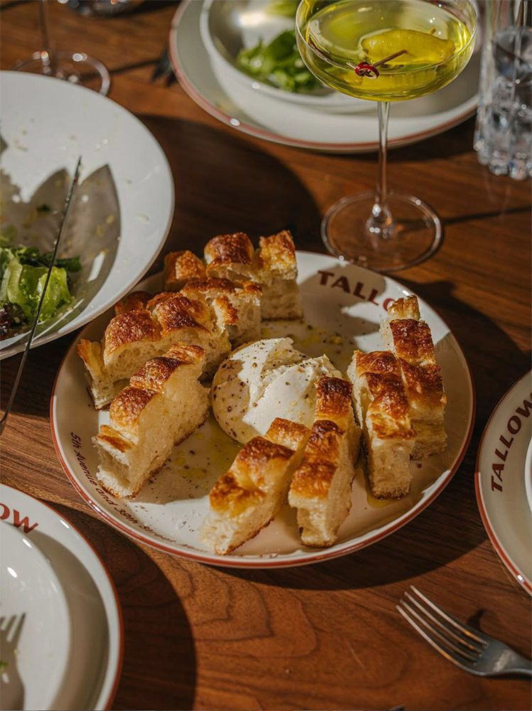 Dining at Tallow in New York, featuring custom tableware and restaurant branding developed by Love & War.