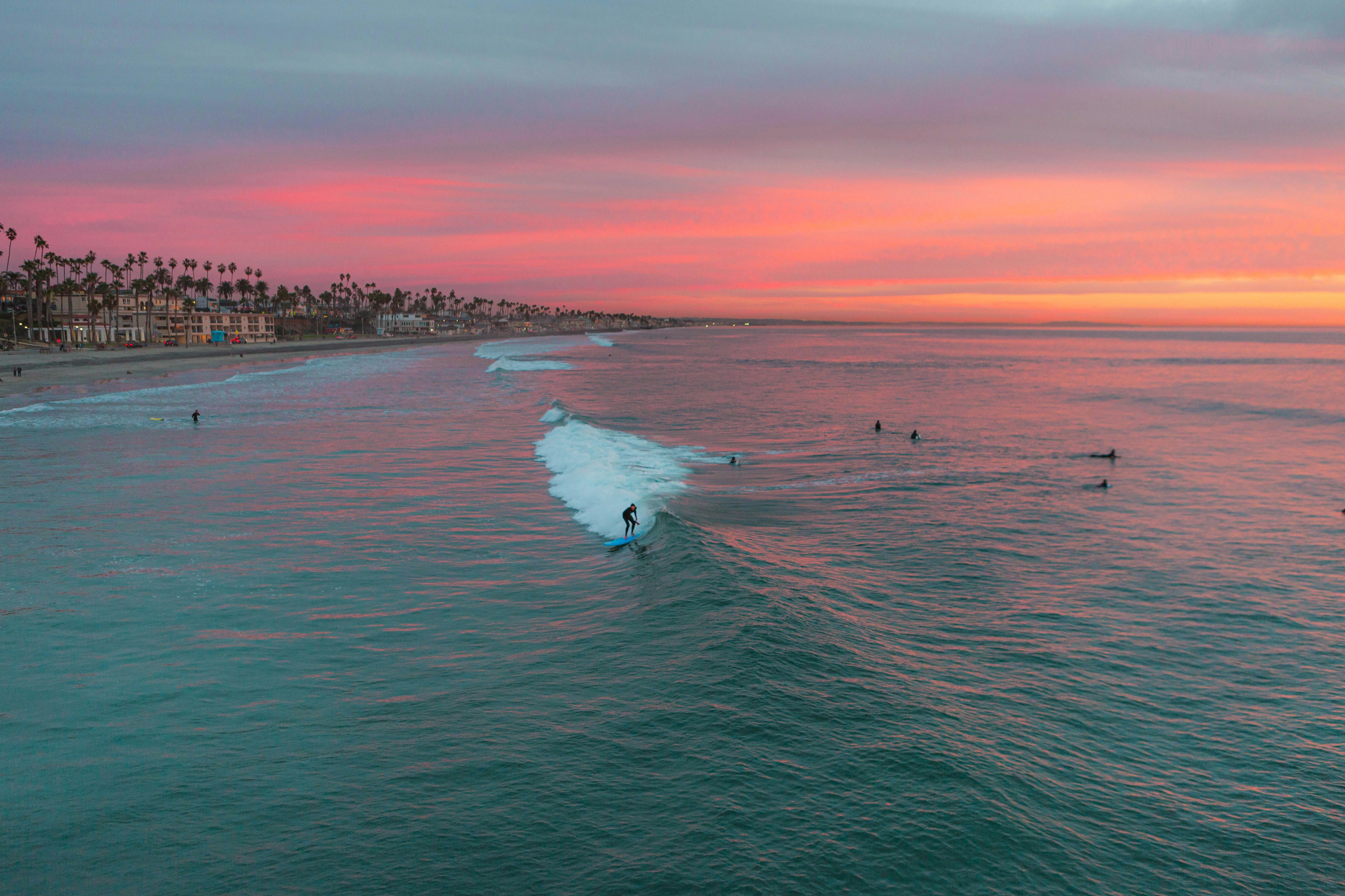 Surfers at sunset along the Oceanside, California coastline near Mission Pacific Beach Resort. Love & War drew on Oceanside’s surf culture, natural landscape, and creative community to develop the hotel’s concept, naming, visual identity, experience design, and marketing, creating a hospitality brand rooted in an authentic Southern California sense of place.