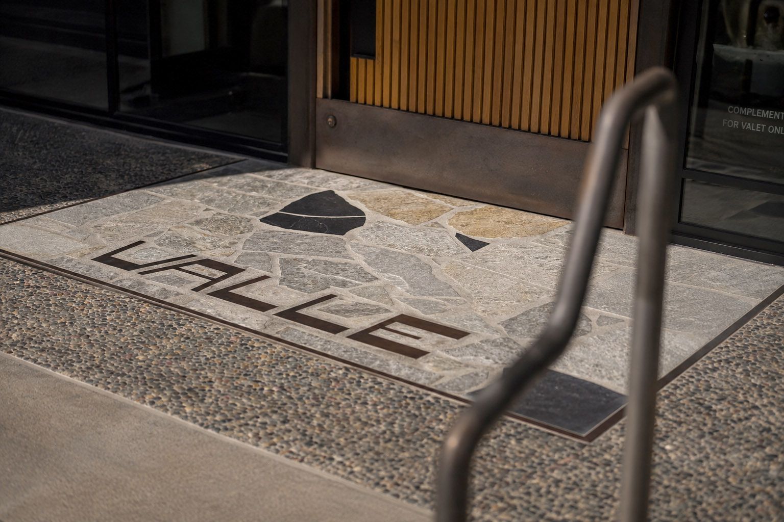 Valle entrance in Oceanside, CA, featuring custom inlaid signage and environmental branding designed by Love & War.