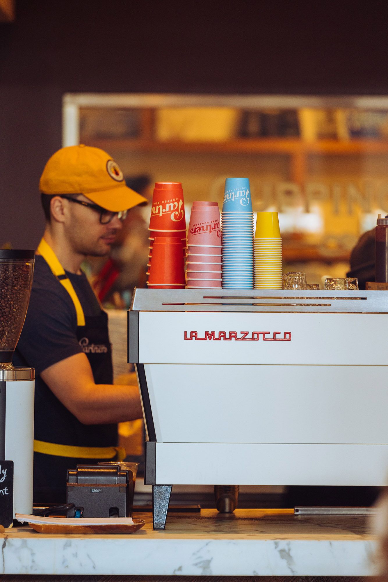 Partners Coffee takeaway cups showcasing the colorful packaging and visual identity designed by Love & War.
