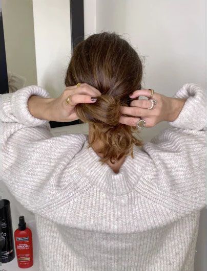 Image of model tieing hair into a bow.