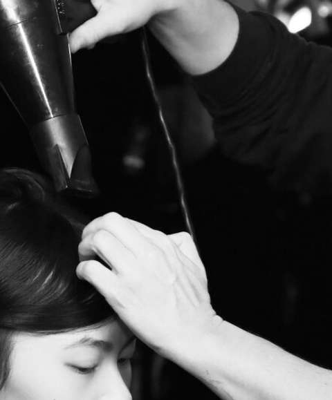 Stylists blowdrying model's hair