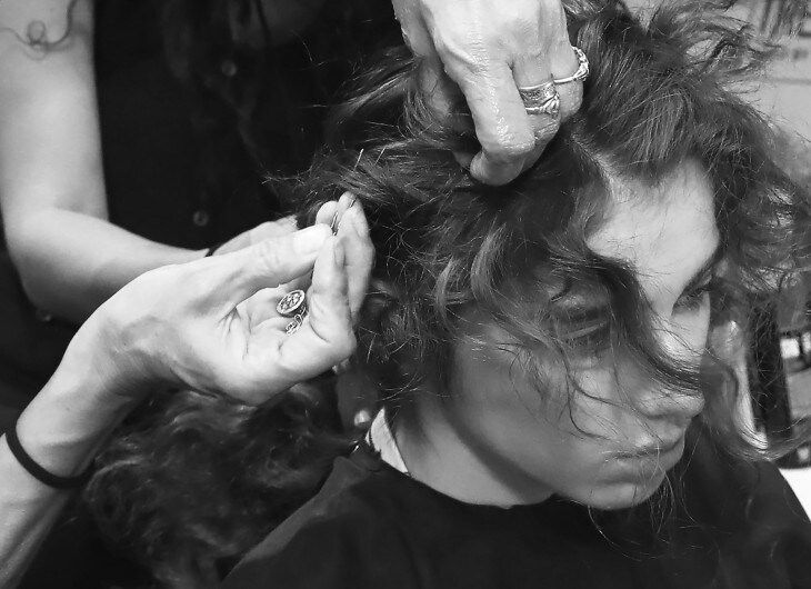Stylist sectioning and twisting model's hair.