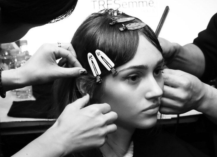 Stylists clipping model's hair