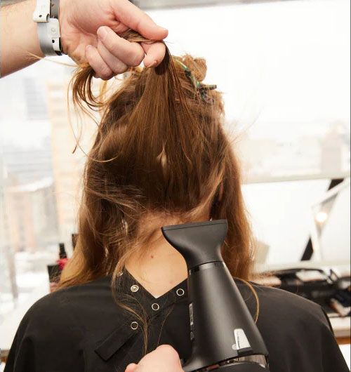 Lift sectioned hair straight up, tightening roots against the back of the head while blowdrying. Repeat steps 1-3, working up and then around the head.