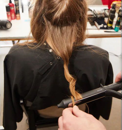 Create soft waves by using a 1-inch curling iron. Start at the root, wrap sectioned hair twice around the barrel, hold for a few seconds, release and move down the strand, and then wrap in the opposite direction. Continue this rotation until the full strand is completed and repeat throughout the rest of the head.