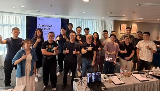 Group of people at an AI Native meetup event posing together with thumbs up gestures.
