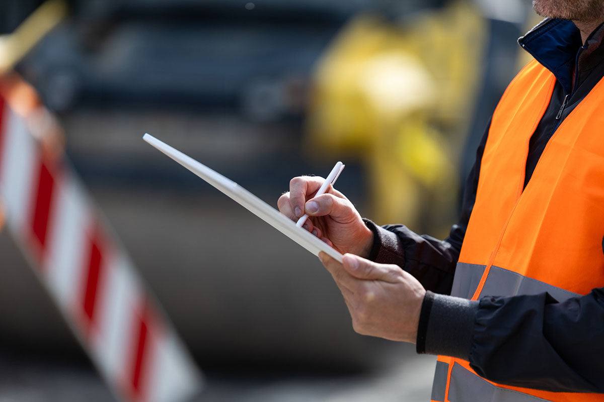 A licensed electrician inspecting a home's switchboard and wiring during a safety inspection.
