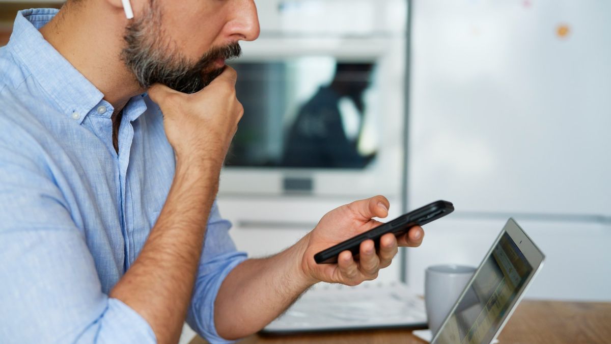 Persona comparando distintas plataformas de subastas inmobiliarias online, en un celular