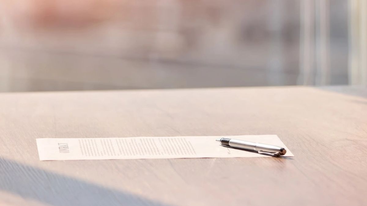 Documentos legales y contrato de compraventa revisados sobre un escritorio luminoso