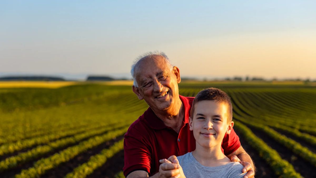 Abuelo y nieto en un campo al atardecer, como los terrenos que compraban los abuelos y hoy se encuentran en subasta