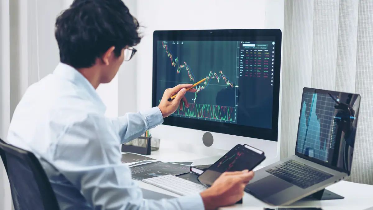 Inversionista revisando gráficos de rentabilidad financiera en múltiples pantallas, en referencia al análisis de datos antes de decidir dónde invertir en propiedades en Chile.