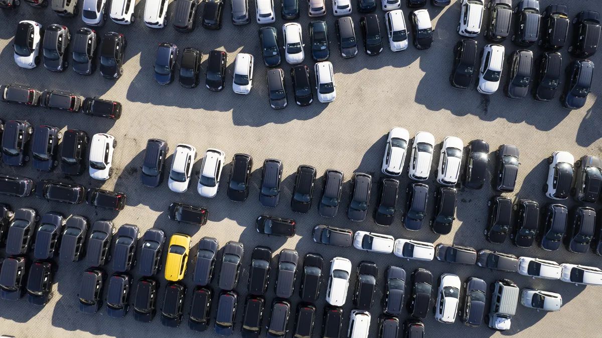 Vista aérea de autos y camionetas usados estacionados en filas, disponibles para subasta en Chile