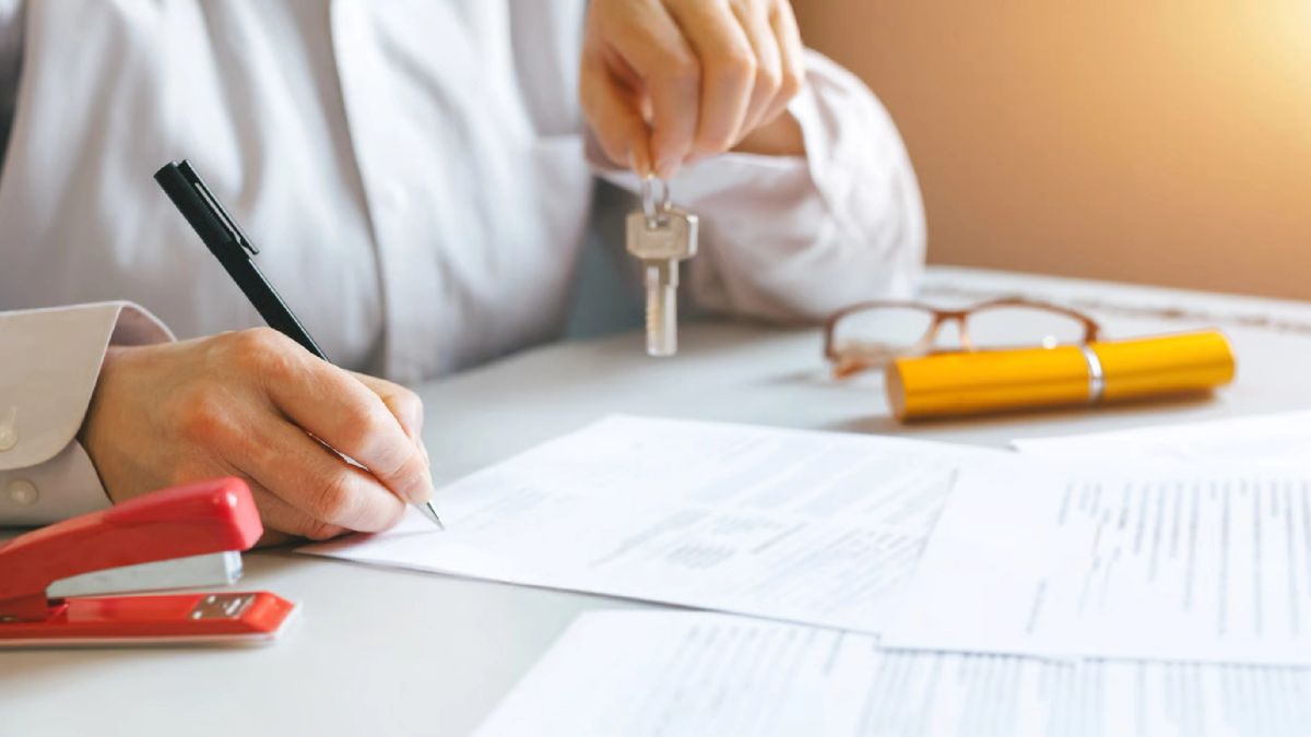 Documentos de escritura y sello notarial sobre un escritorio, representando el proceso de inscripción tras adjudicar una propiedad en subasta