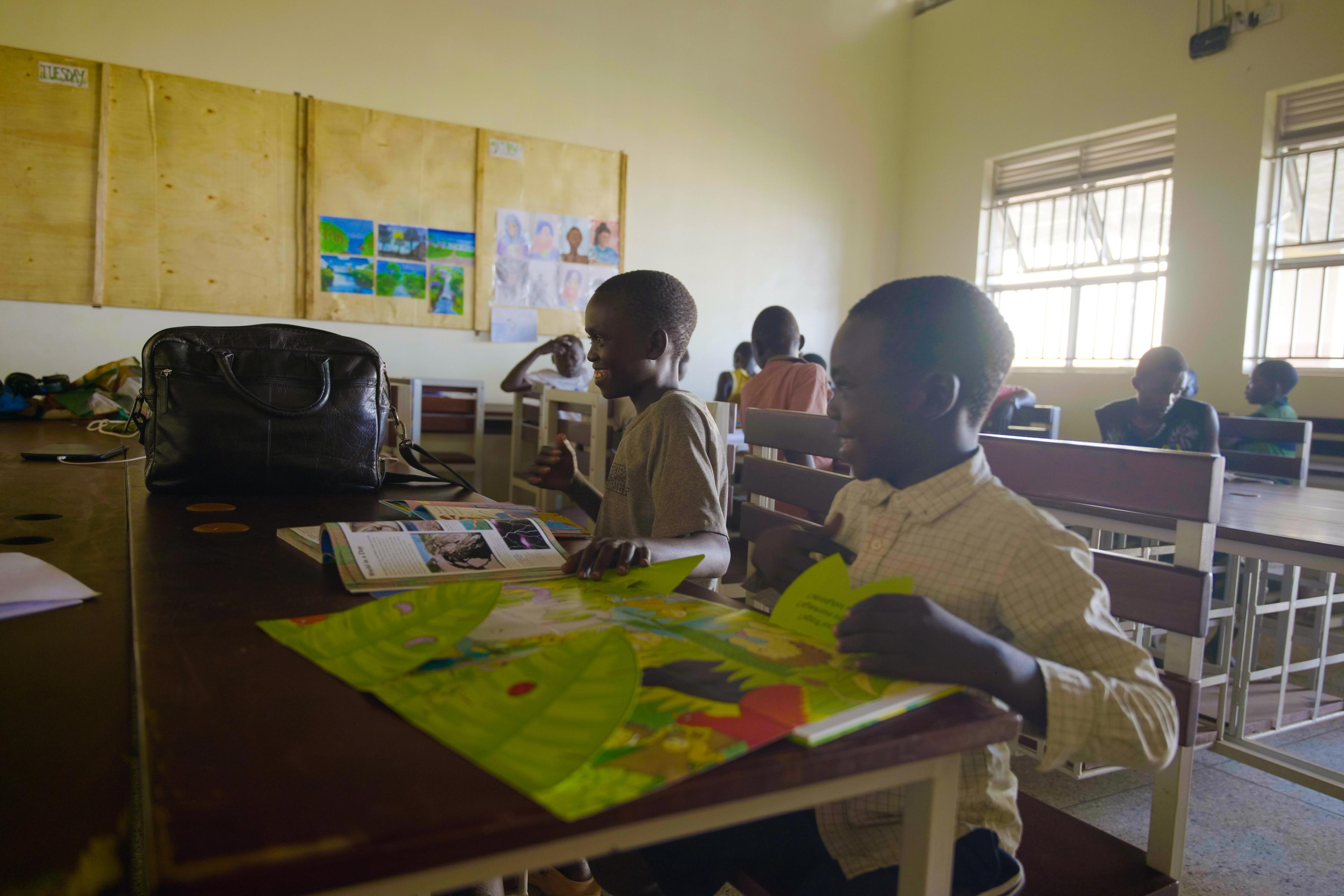Smiling Creative Learning Haven students sharing a book.