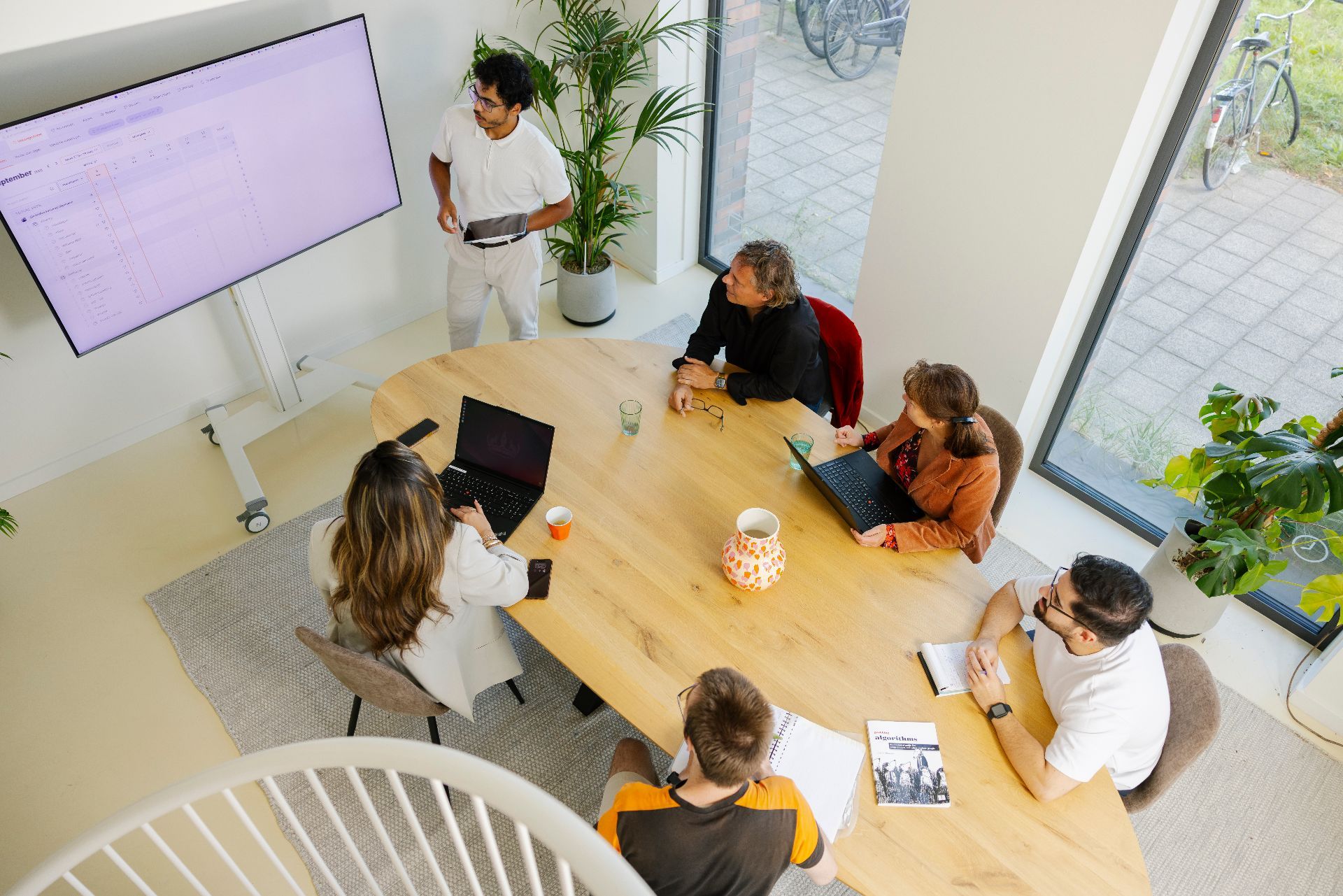 Foto van mensen rondom een vergadertafel