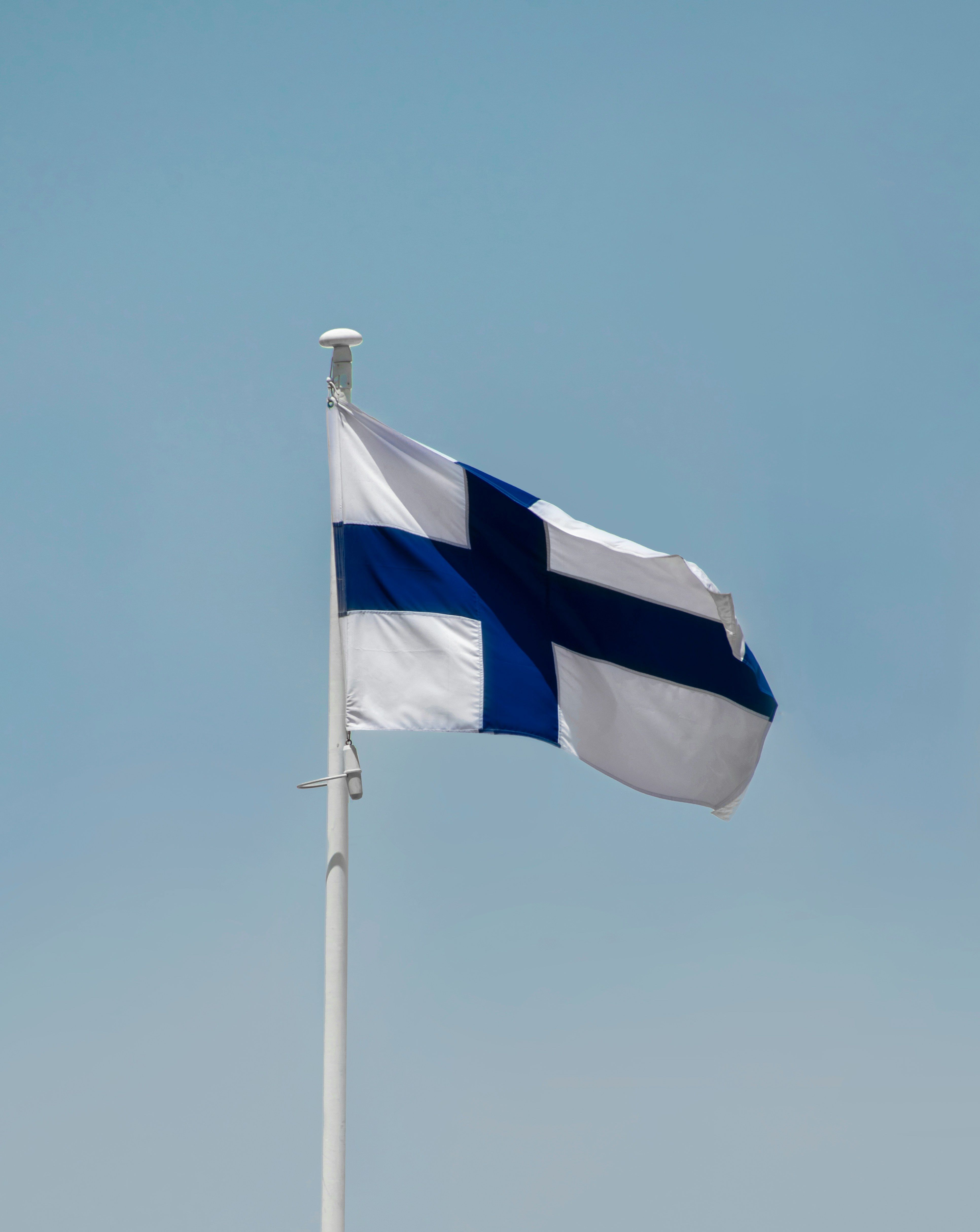 Flaga Finlandii powiewa na wietrze w bezchmurny dzień.