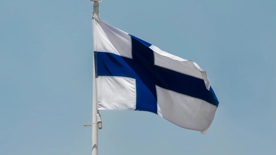 Flaga Finlandii powiewa na wietrze w bezchmurny dzień. Flaga Finlandii powiewa na wietrze w bezchmurny dzień.