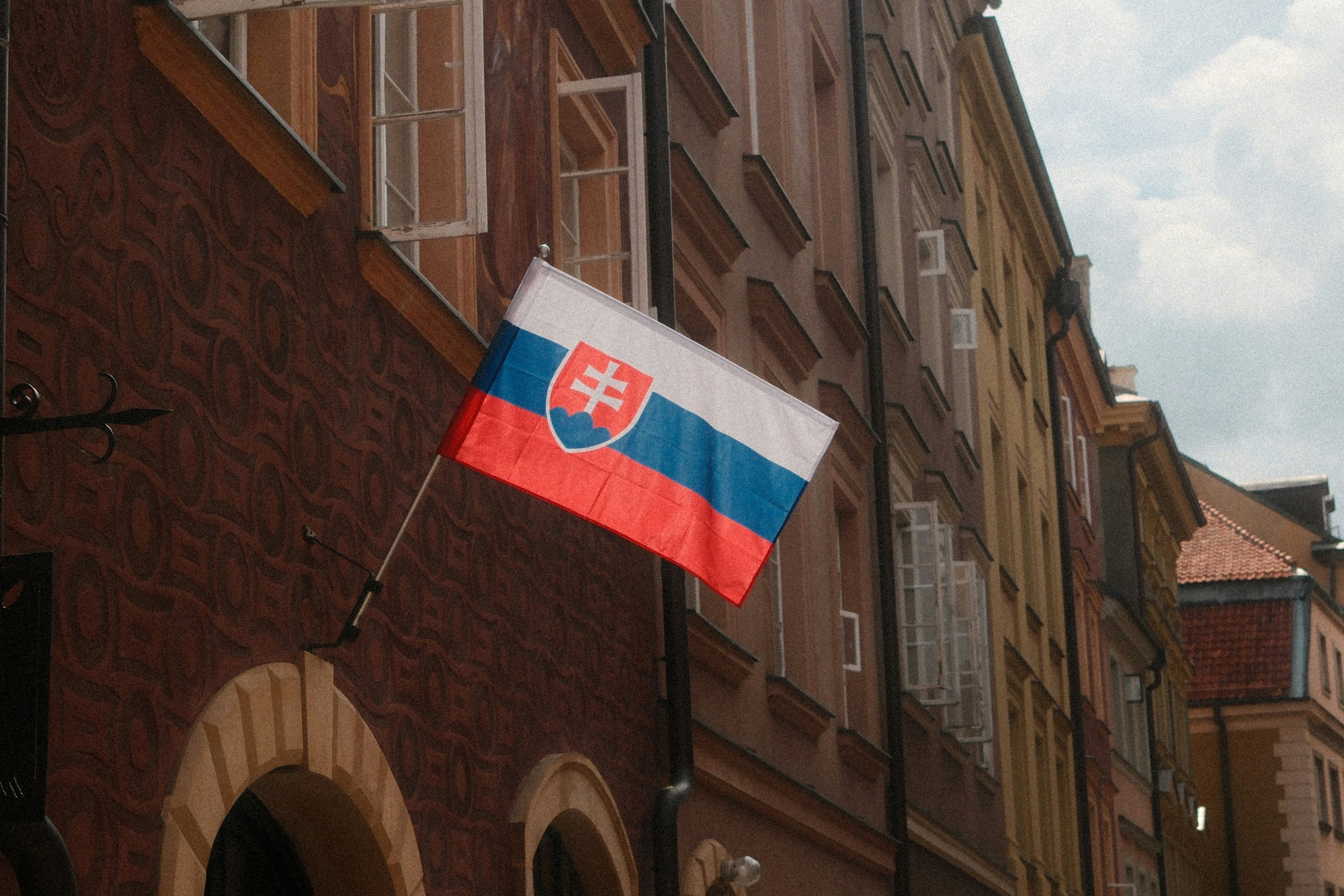Flaga Słowacji zawieszona na ścianie budynku z cegły.