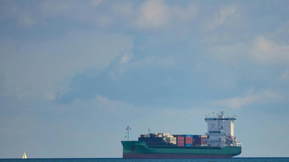 Duży statek typu kontenerowiec wiezie ładunki na oceanie pod spokojnym niebem Duży statek typu kontenerowiec wiezie ładunki na oceanie pod spokojnym niebem