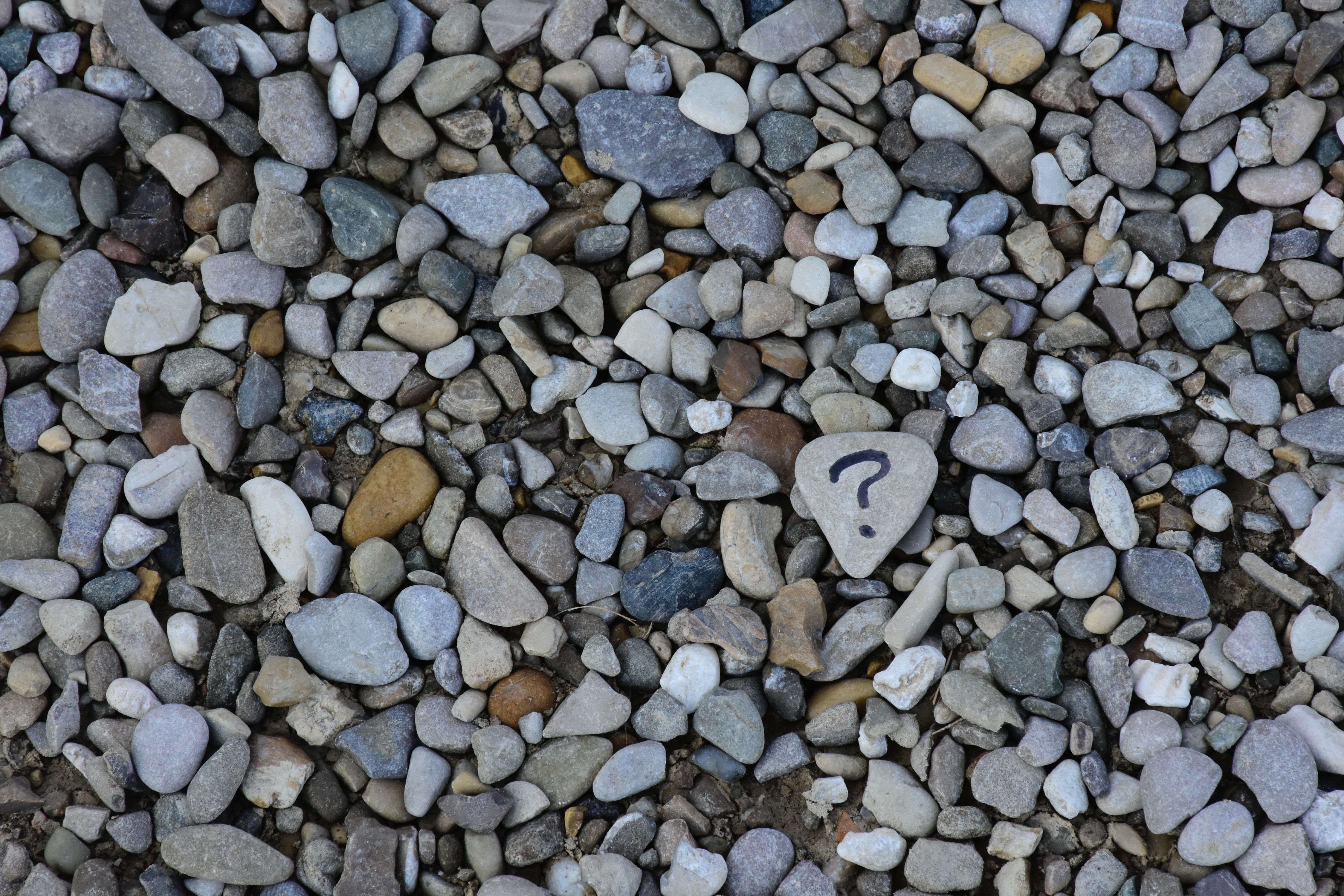 Close-up image of rocks and a question mark 