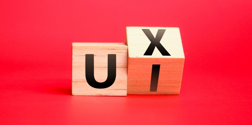 Two wooden blocks showing the letters UX and UI