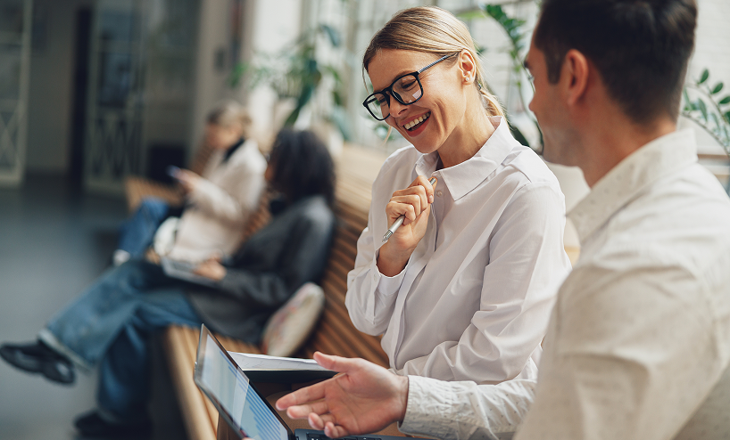 two people smiling and working together
