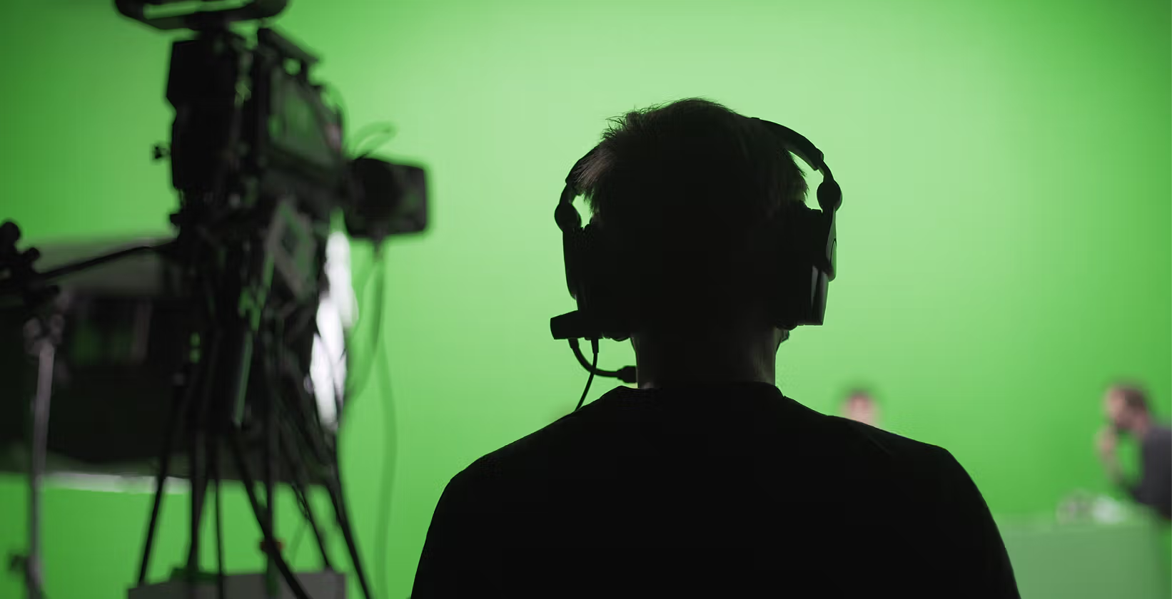 Man with camera in front of green screen