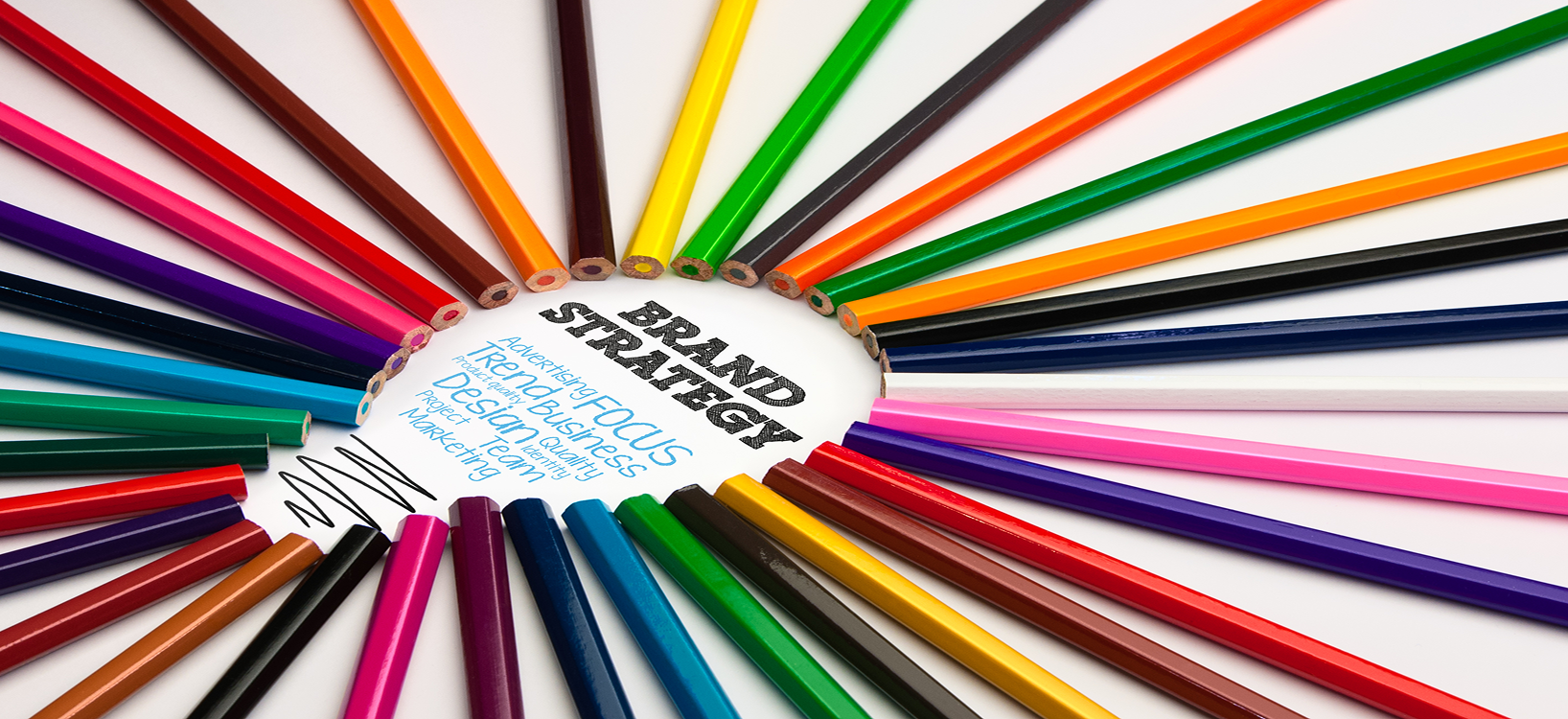 coloured pencils lined up to shape the outline of a lightbulb with text in the center saying brand strategy