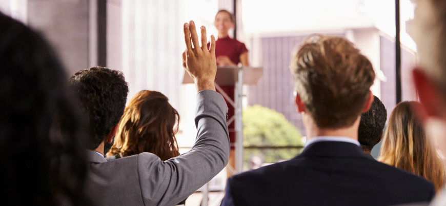 person holding hand up in crowd