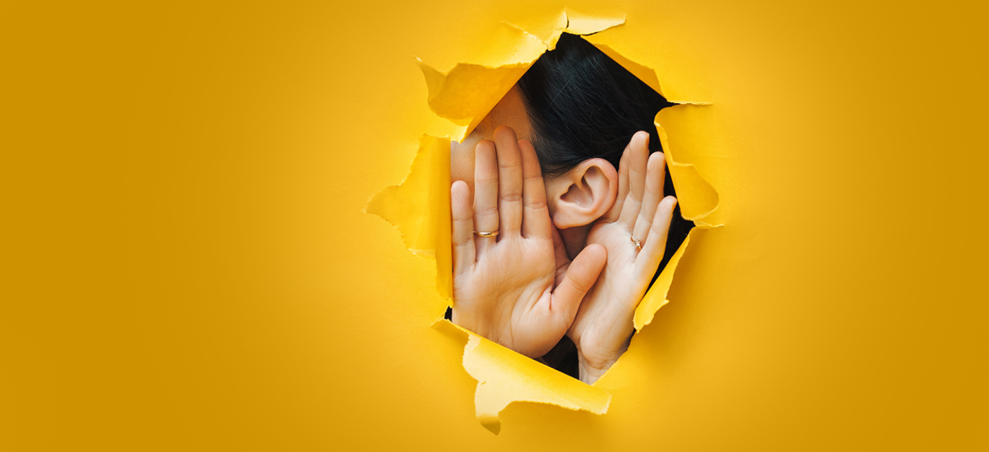 Someone with hands to ear, listening