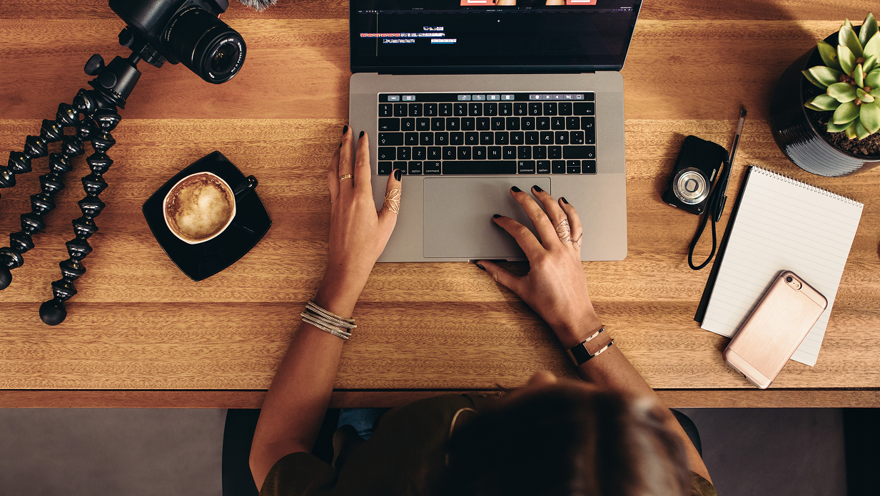 View from above showing someone on their laptop editing a video in video editing software