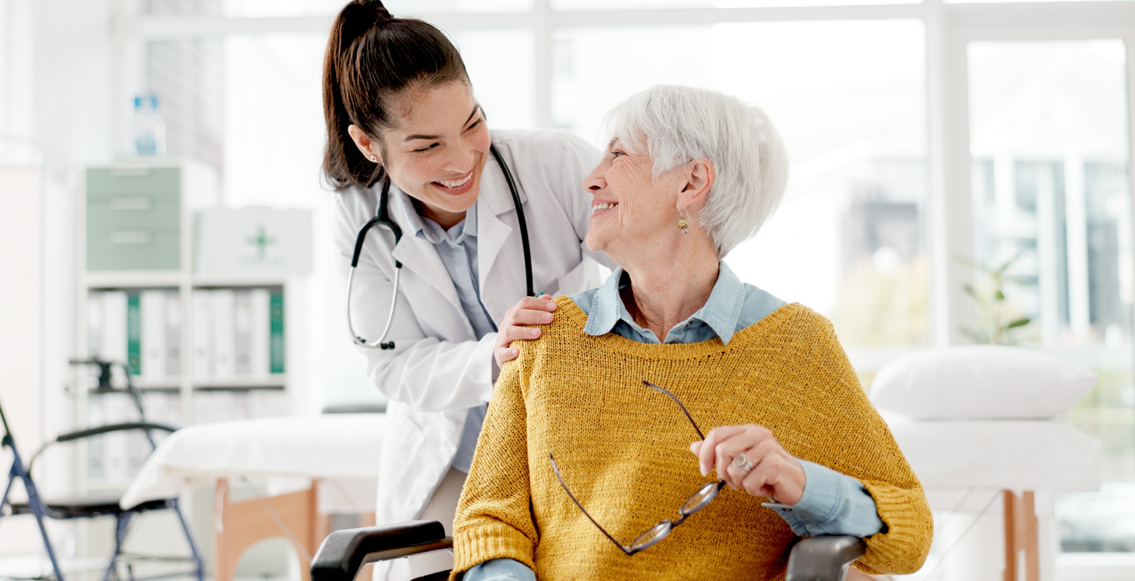 doctor smiling at elderly lady in yellow jumper