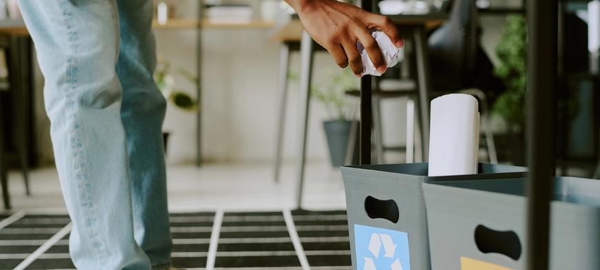 person dropping rubbish in a bin