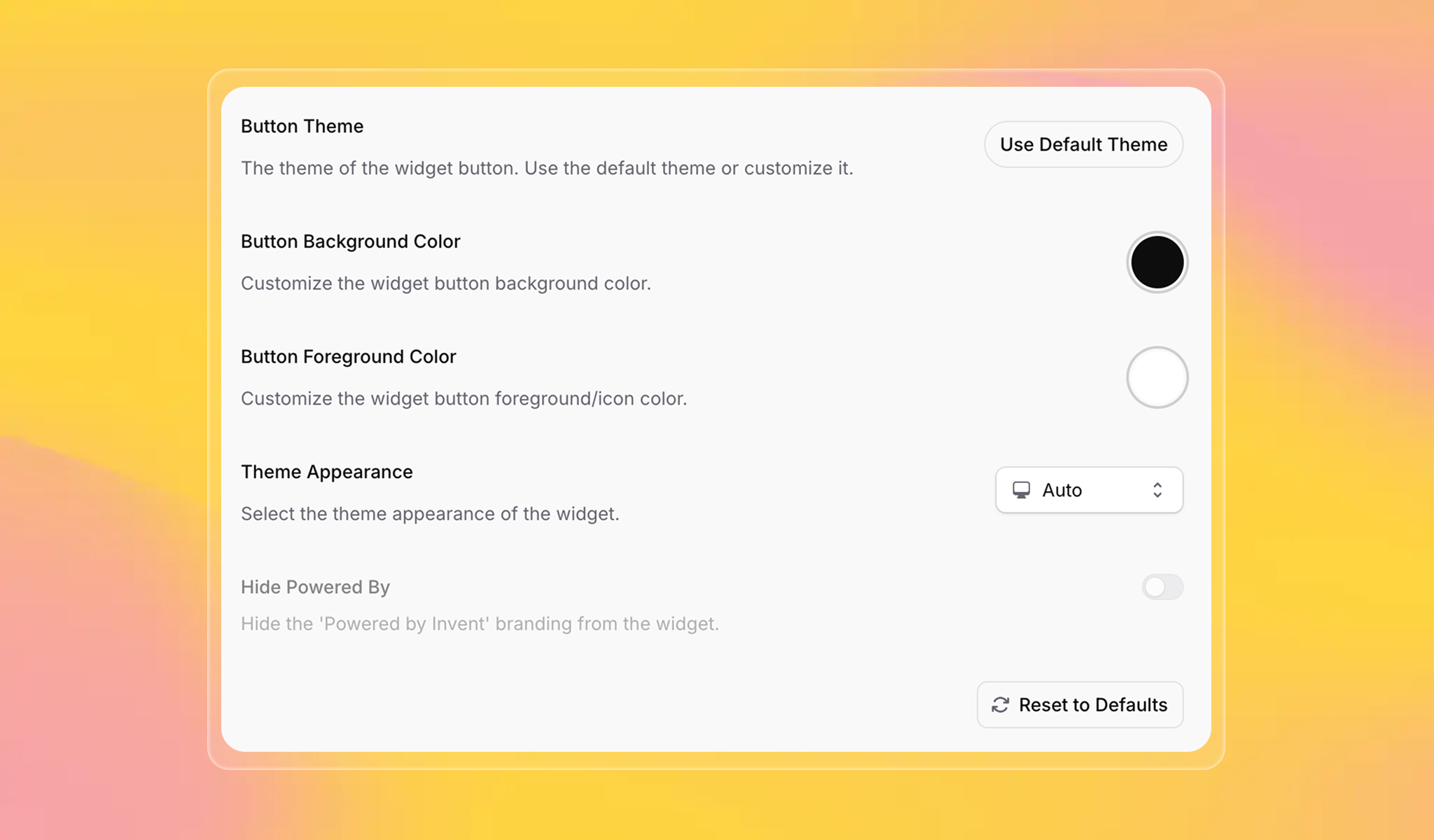 A UI screenshot shows customization options for an Invent chatbot widget. Settings include: Button Theme selection, Button Background Color (with a black color picker), Button Foreground Color (white color picker), Theme Appearance (with auto/dark/light mode dropdown), and a toggle to hide “Powered by Invent” branding. There's also a “Use Default Theme” button and “Reset to Defaults” option. Background is a bright yellow-orange-pink gradient.