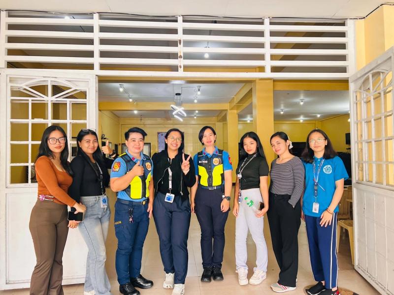 Group photo of student participants and uniformed personnel inside the seminar hall