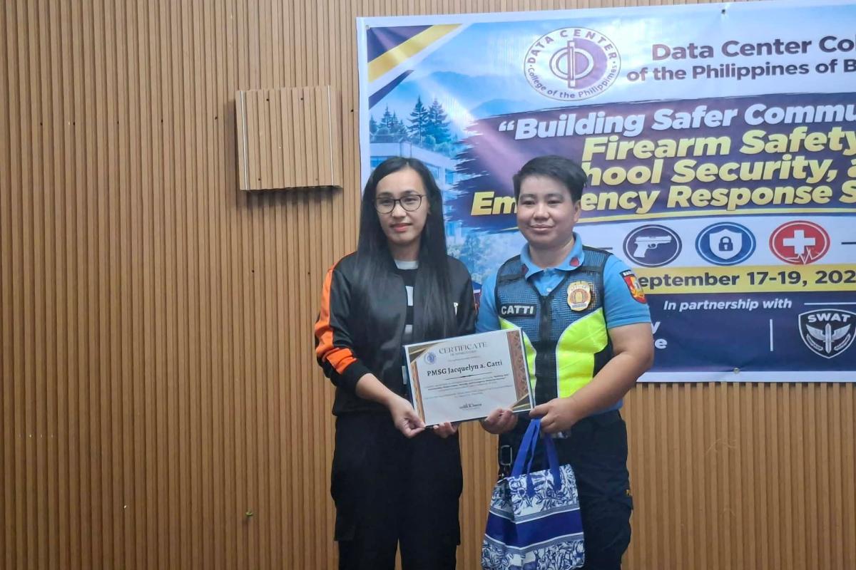 DCCP representative handing a certificate of appreciation to a Baguio City police officer in a reflective vest during the seminar
