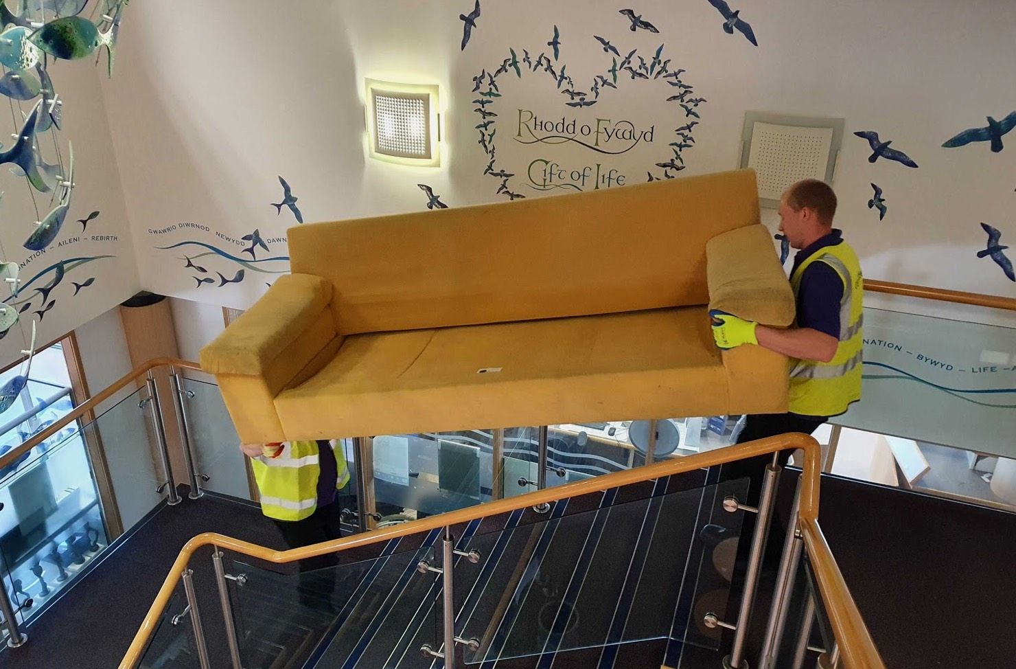 operatives carrying sofa downstairs