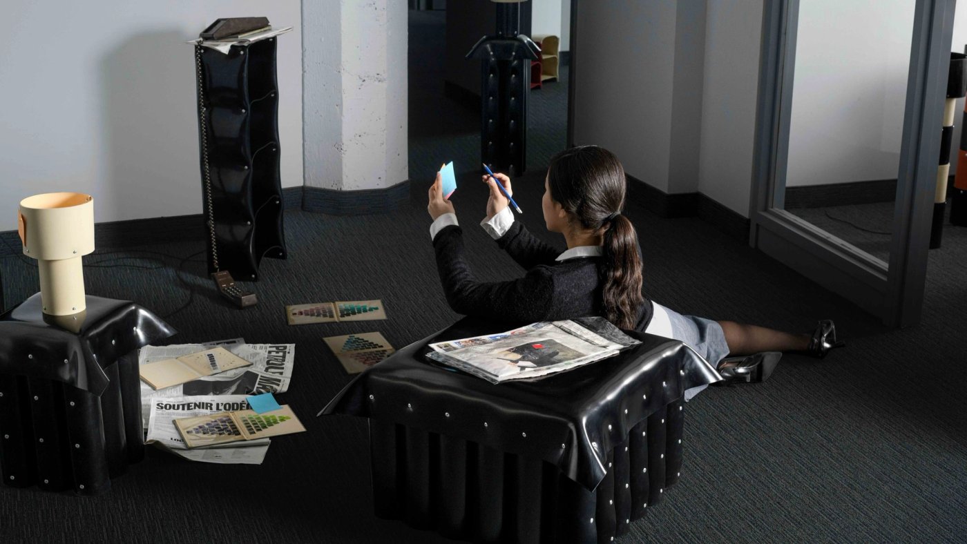 "The Rubber Libraries bookshelves consist of a black rubber sheet and aluminum rivets, nothing else. No hidden frame, and no metal armature doing the actual work. Just rubber cut and riveted like fabric, holding weight and functioning as furniture."