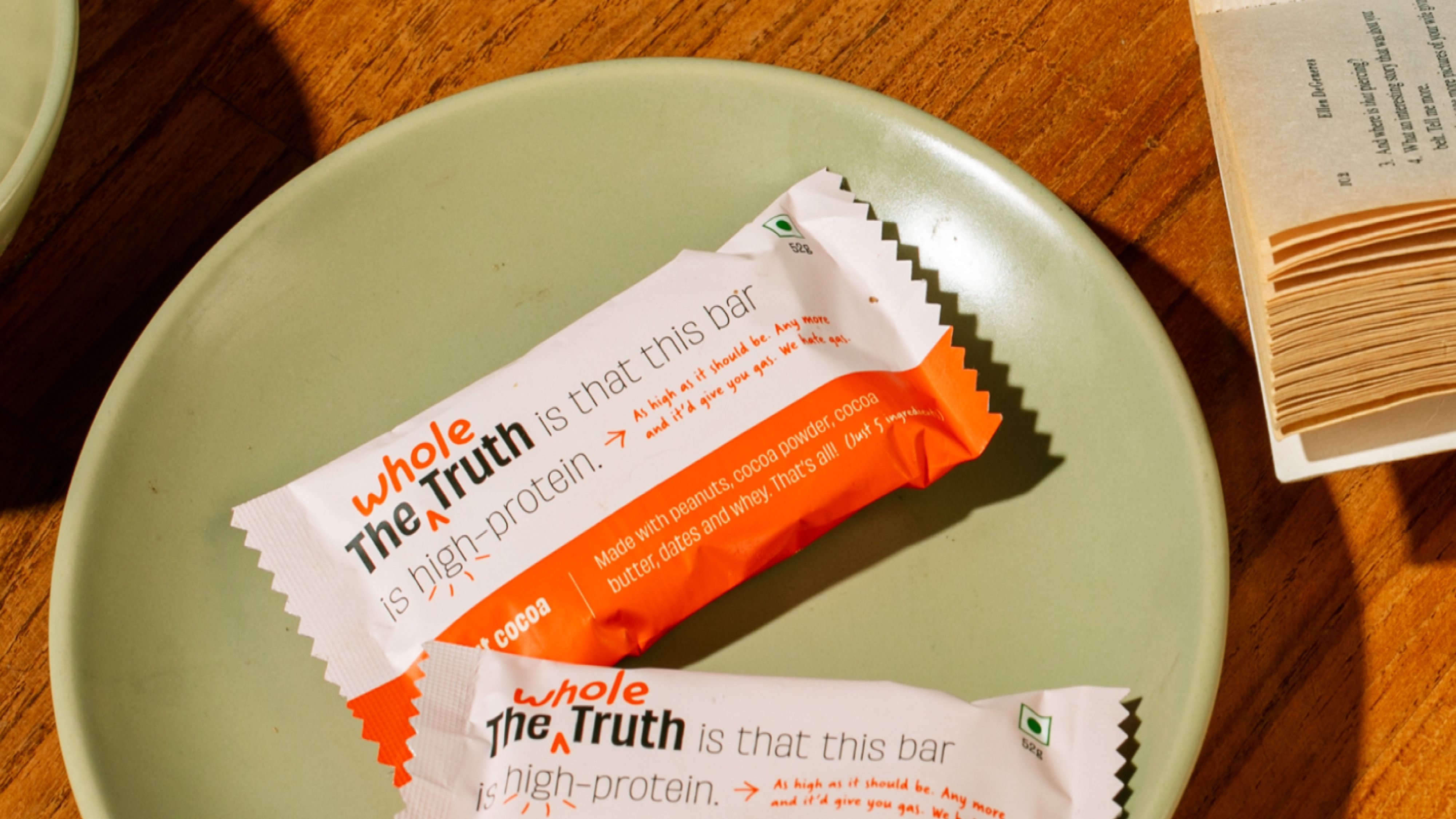 Packaging for The Whole Truth protein bar on a green plate