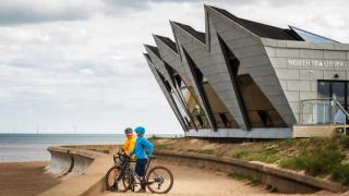 Two cyclists by the North Sea Observatory