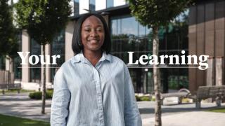 Student stood in front of text saying Your Learning