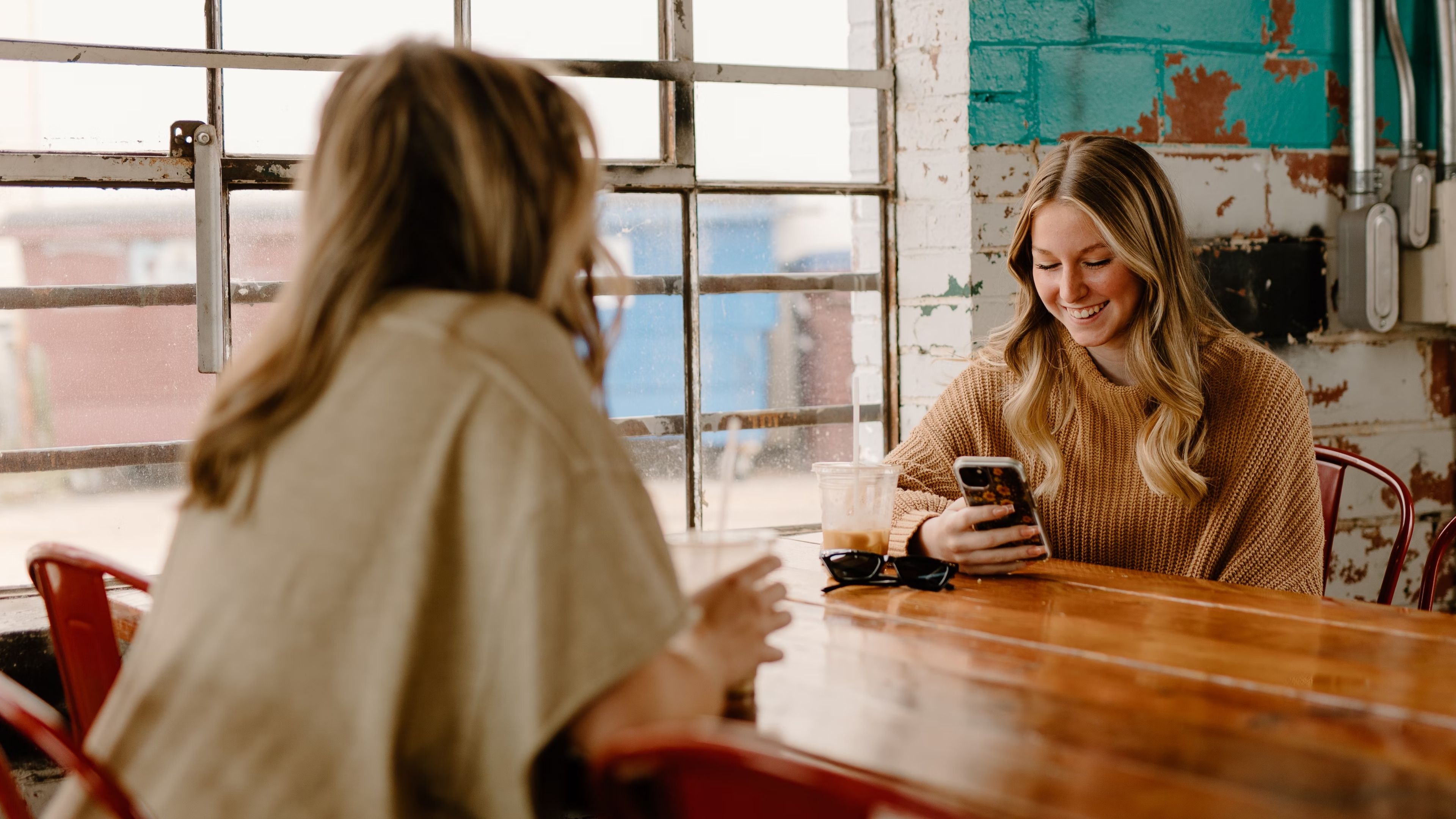 Women in cafe using phones