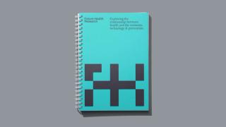 Branded notebook with the text Exploring the relationship between health and the economy, technology & prevention.