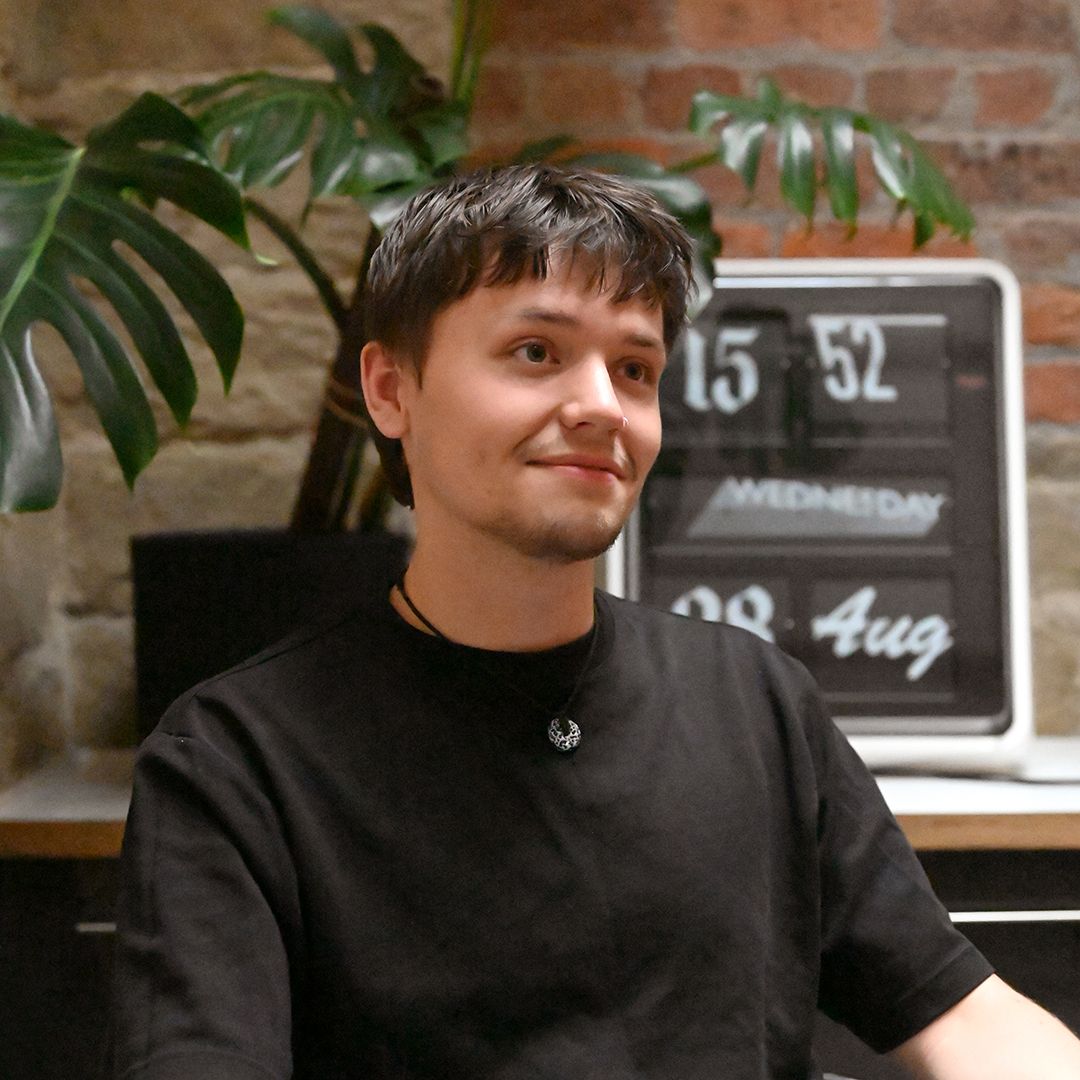 image of person in the centre with a clock and plant in the background