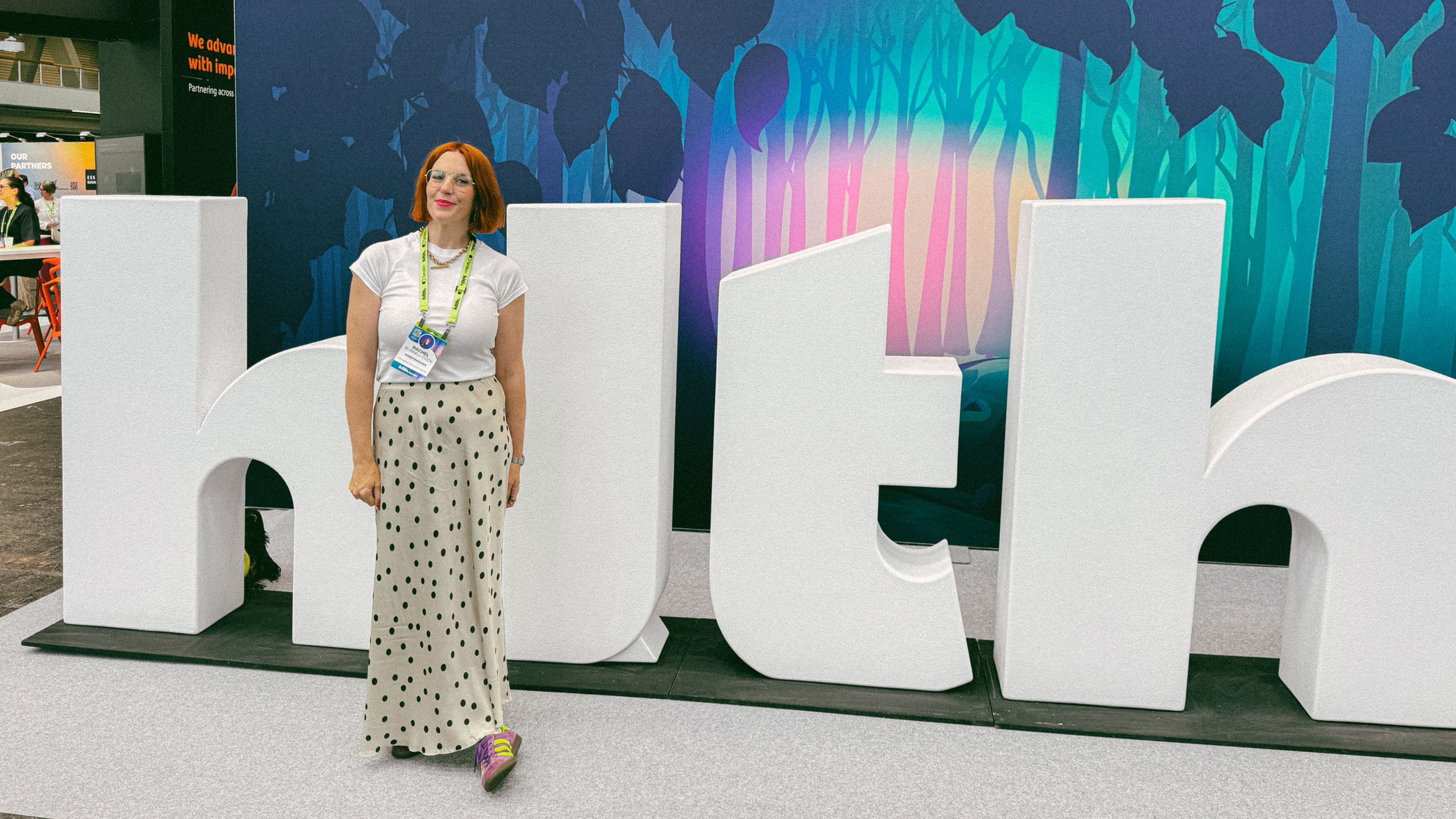 Rachel standing in front of a giant HLTH sign at the HLTH Europe conference.