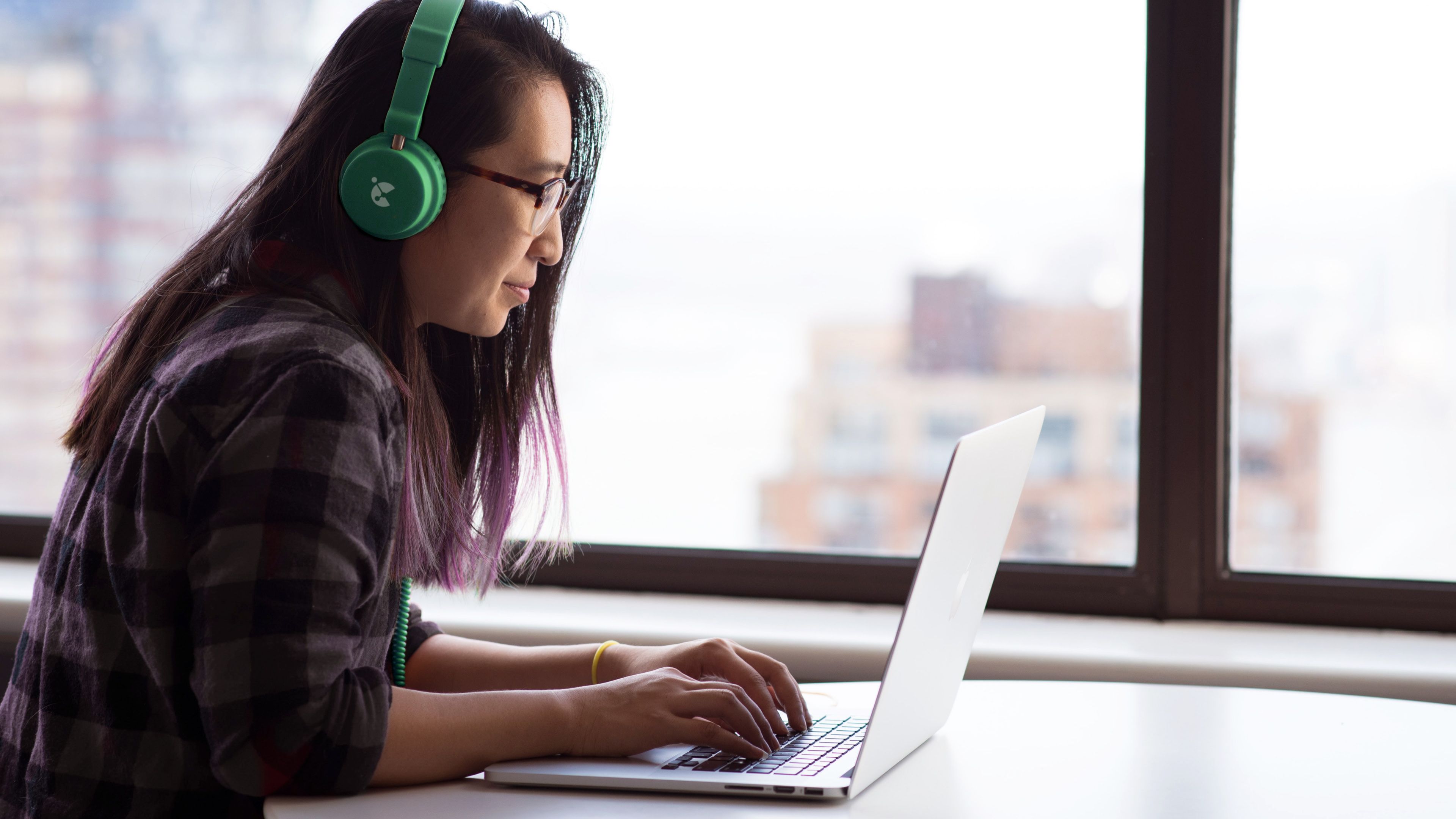 Person working at computer wearing Censeo branded headphones