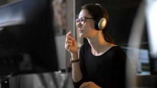Person wearing headphones looking at computer screen