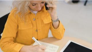 Person on phone taking notes